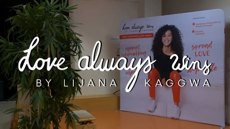 Love Always Wins by Lijana Kaggwa – Bühne und Banner einer Schulveranstaltung gegen Cybermobbing
